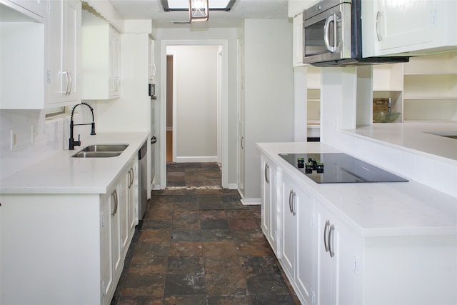 kitchen with backsplash, stainless steel appliances, dark tile flooring, white cabinets, and sink