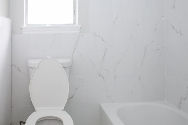 bathroom with tile walls and toilet