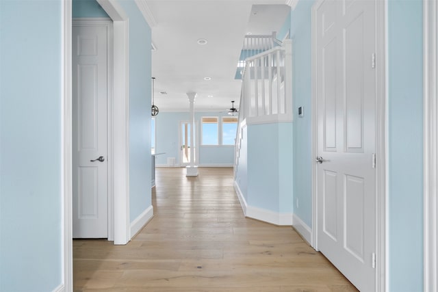 corridor with light hardwood / wood-style flooring and ornamental molding