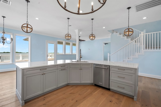 kitchen with gray cabinetry, hanging light fixtures, dishwasher, light wood-type flooring, and sink