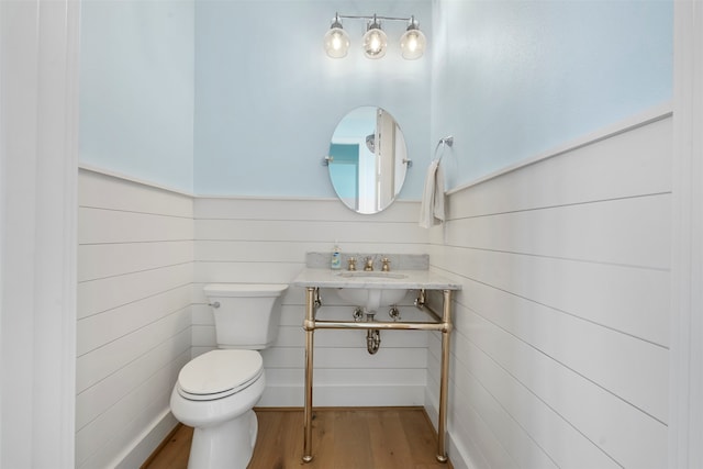 bathroom with a sink, toilet, and wood finished floors