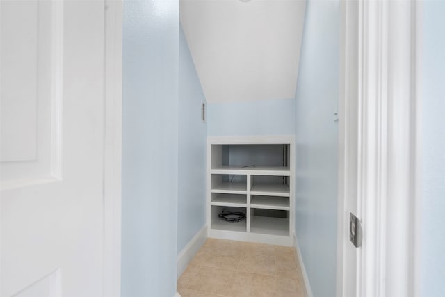 interior space with vaulted ceiling and light tile patterned floors