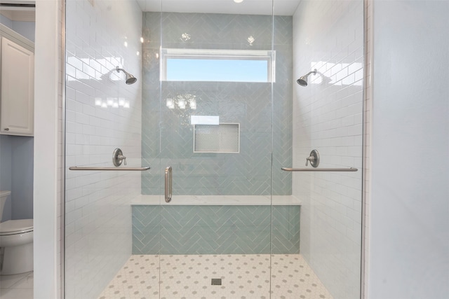 bathroom with a shower stall and toilet