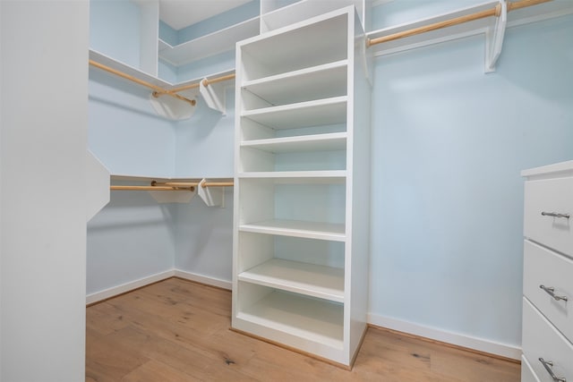 walk in closet with hardwood / wood-style floors