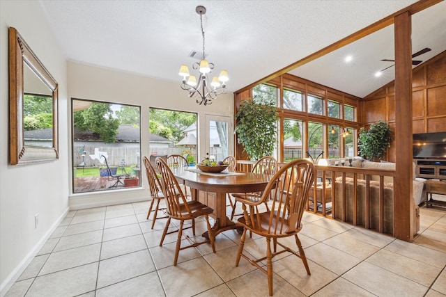 dining space with vaulted ceiling, light tile floors, and ceiling fan with notable chandelier