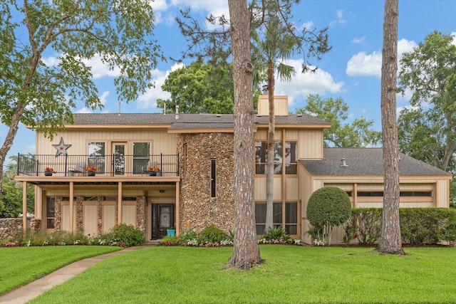 view of front facade featuring a front yard and a balcony