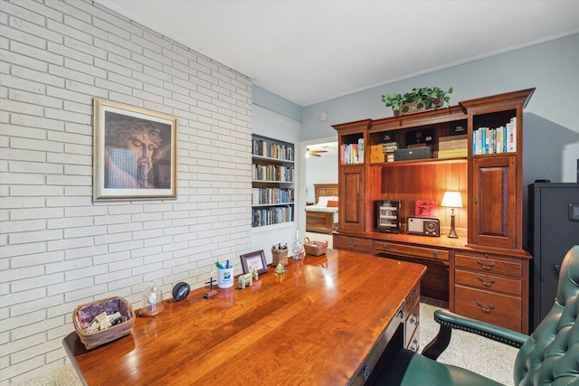 carpeted office featuring brick wall and built in features