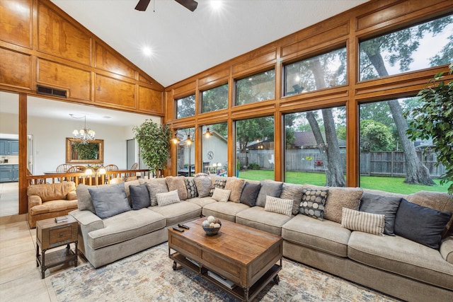 living room with high vaulted ceiling, tile flooring, and ceiling fan with notable chandelier