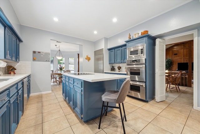 kitchen featuring backsplash, built in appliances, blue cabinetry, a center island, and light tile floors