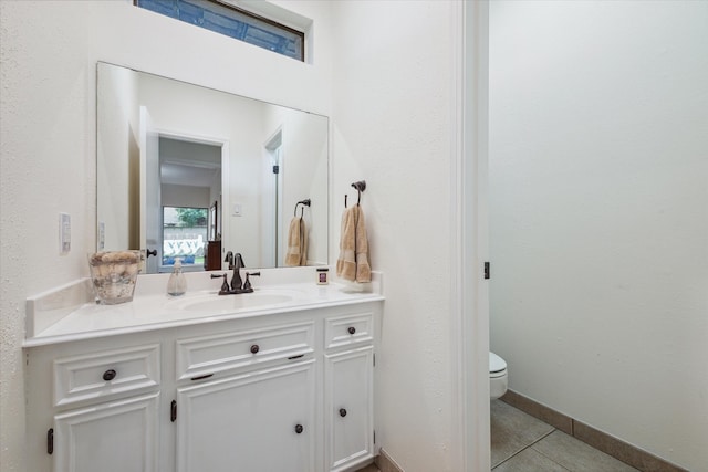 bathroom featuring tile floors, large vanity, and toilet