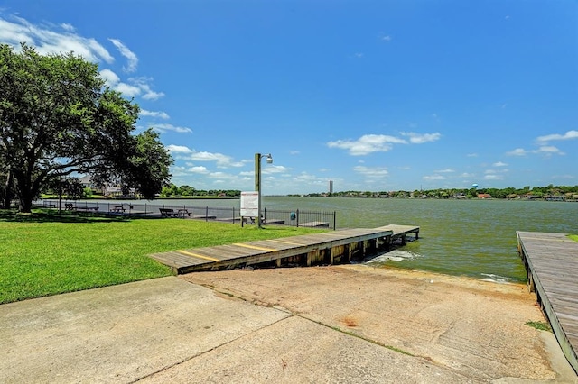 view of dock with a water view and a yard