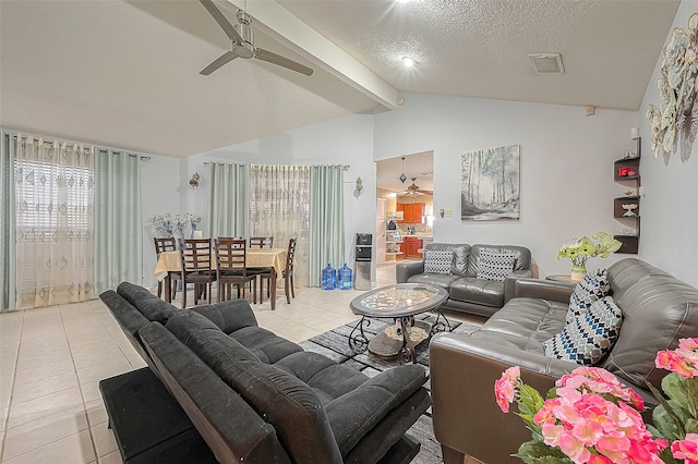 living room with a textured ceiling, lofted ceiling, ceiling fan, and light tile floors