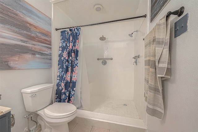 bathroom featuring tile flooring, a textured ceiling, curtained shower, vanity, and toilet