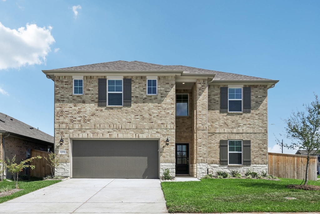 view of front of property with a front yard and a garage