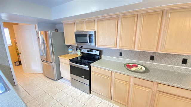 kitchen with appliances with stainless steel finishes, light tile floors, and light brown cabinets