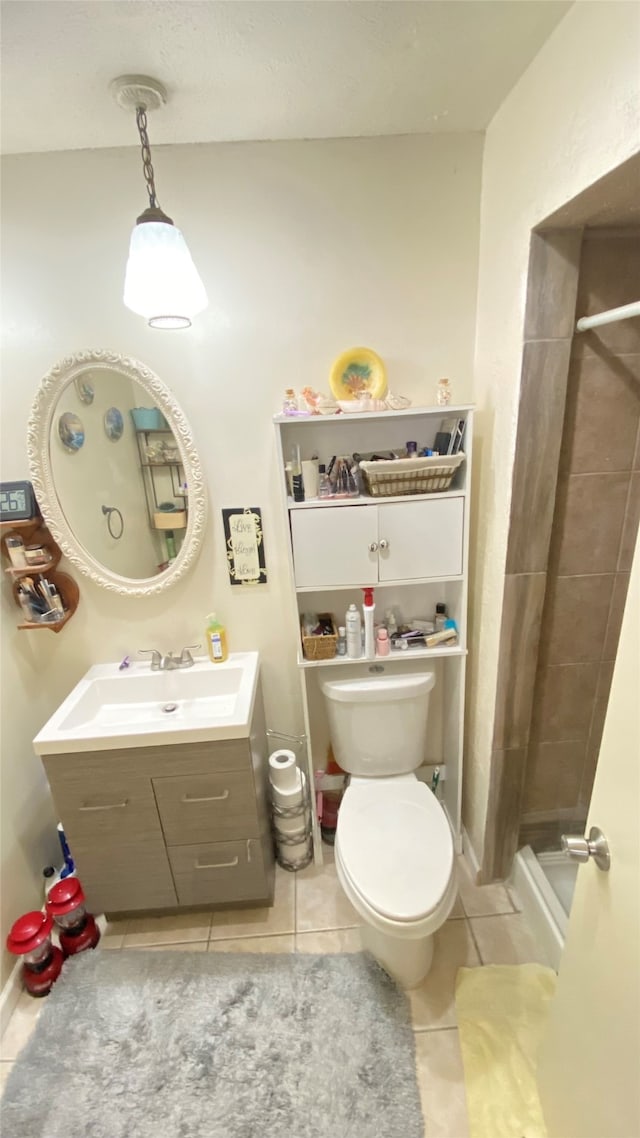 bathroom with tile flooring, oversized vanity, toilet, and a shower