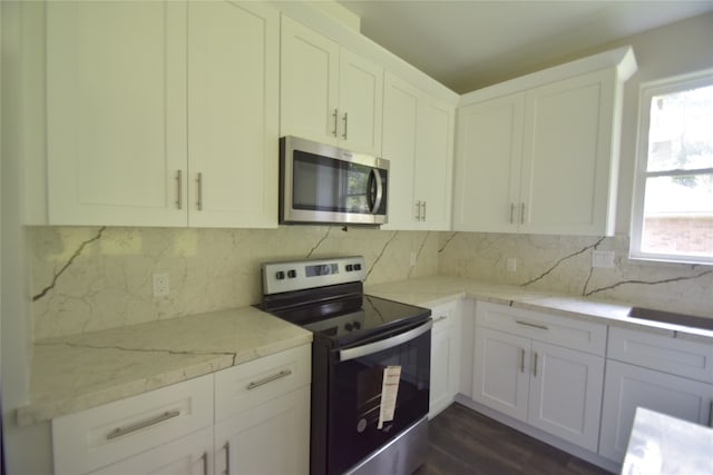 kitchen featuring white cabinets, dark hardwood / wood-style floors, decorative backsplash, light stone countertops, and appliances with stainless steel finishes