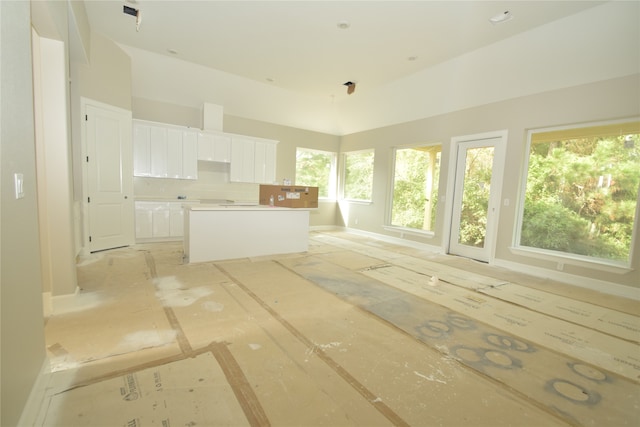 interior space featuring white cabinets, decorative backsplash, and a center island