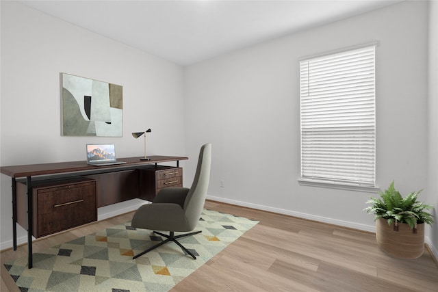 home office with light hardwood / wood-style floors