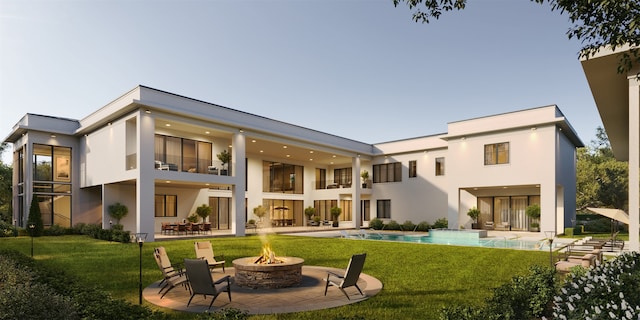 back of property featuring a lawn, a patio area, and a fire pit