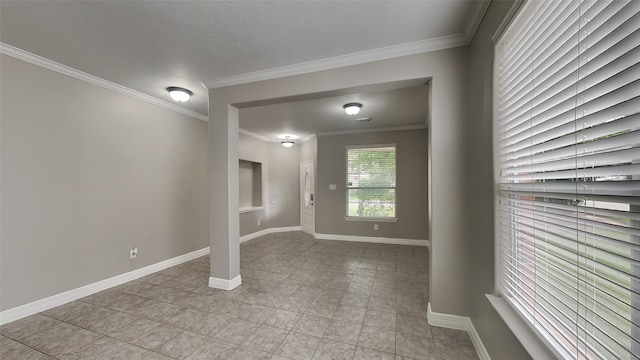 tiled spare room featuring ornamental molding