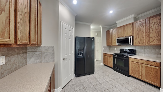 kitchen with backsplash, black appliances, light tile floors, and crown molding