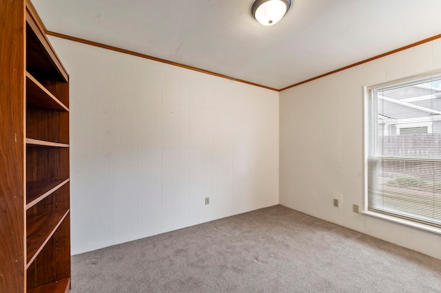 unfurnished room with ornamental molding and carpet floors