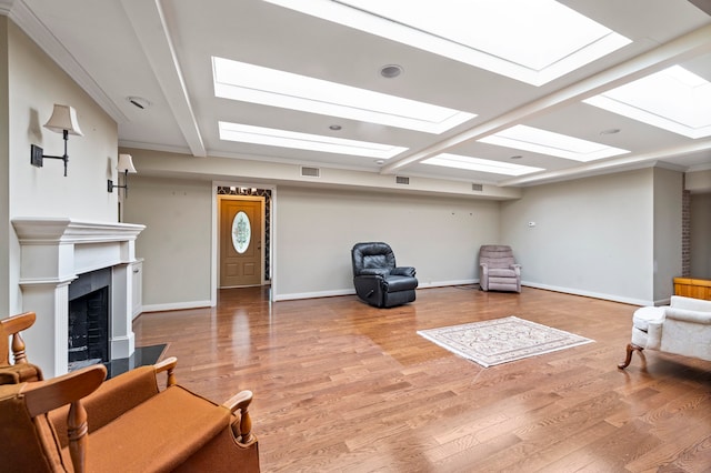 living room with ornamental molding, a skylight, and wood-type flooring