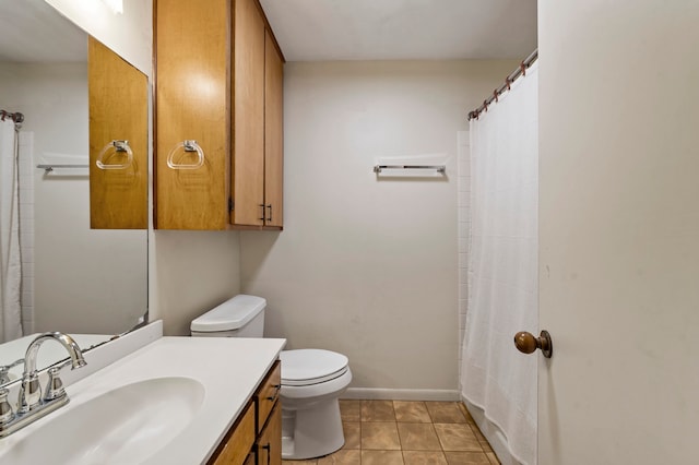 bathroom with tile floors, toilet, and vanity