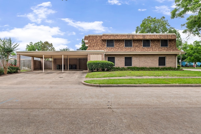 view of front facade with a front lawn and a carport