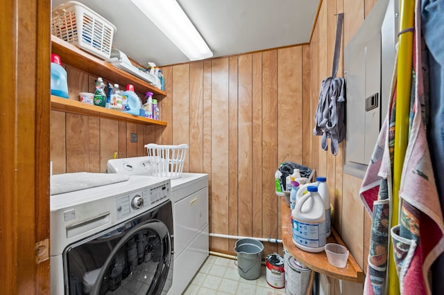 washroom featuring light tile floors, separate washer and dryer, and wood walls