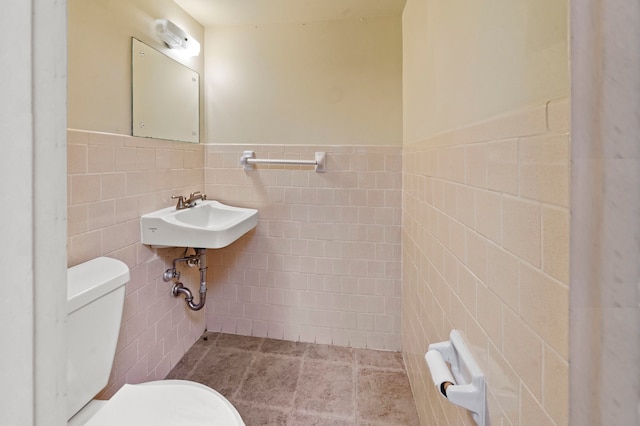 bathroom featuring tile walls, sink, tile flooring, and toilet