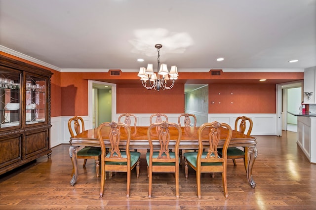 dining area with wood-type flooring, a chandelier, and ornamental molding