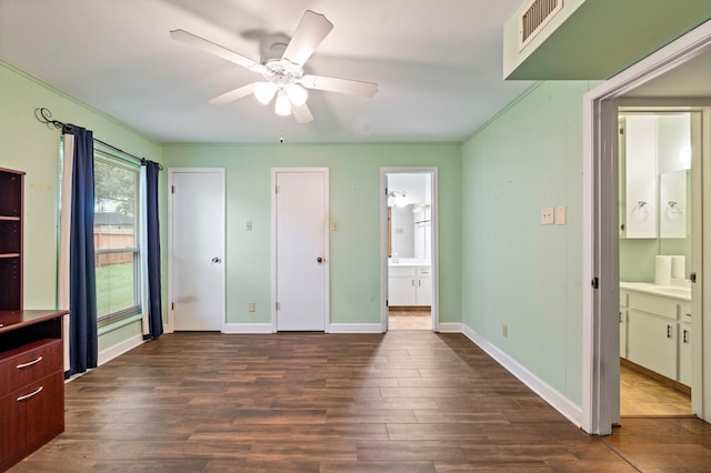 unfurnished bedroom with ensuite bath, ceiling fan, and dark hardwood / wood-style floors