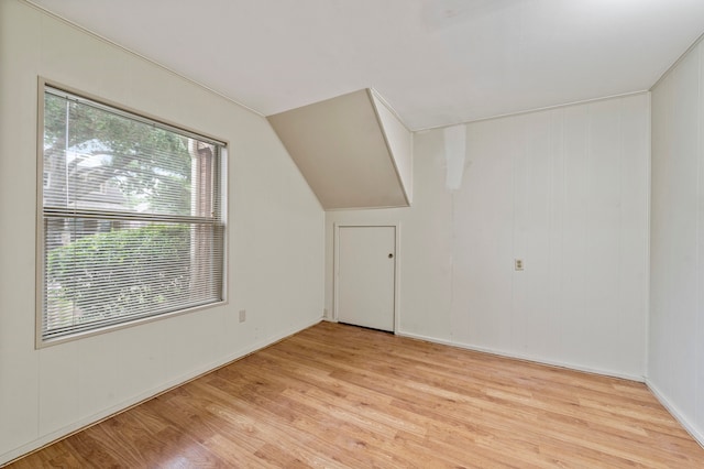 bonus room with light hardwood / wood-style floors and lofted ceiling