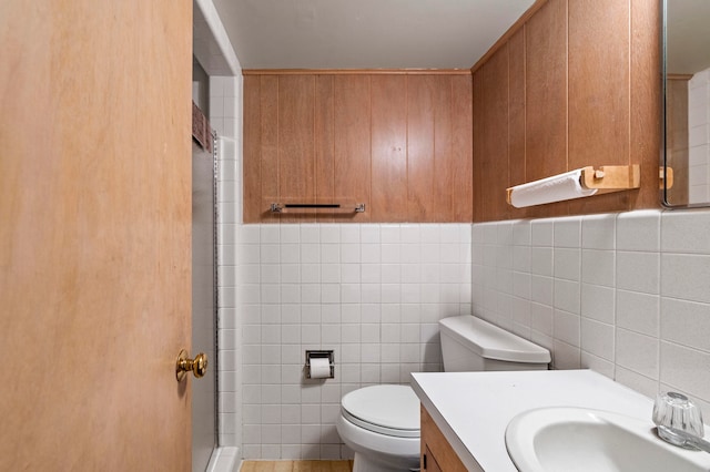 bathroom with tile walls, toilet, and vanity