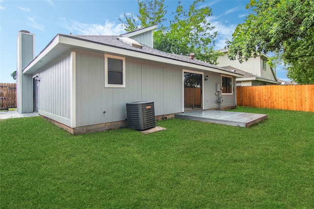 back of property with central air condition unit and a lawn