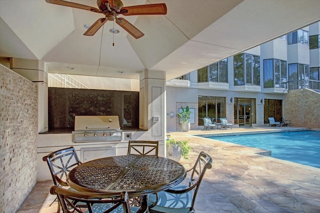 view of pool featuring ceiling fan, a patio area, exterior kitchen, and grilling area