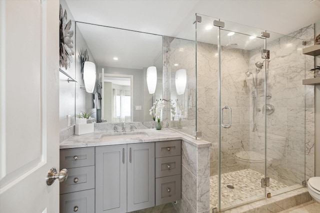 bathroom with vanity, toilet, and a shower with shower door