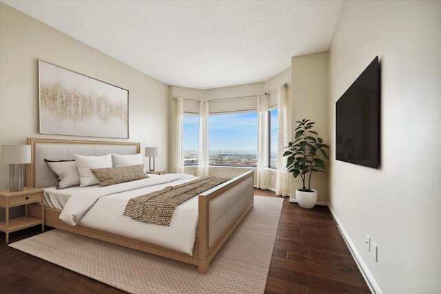 bedroom with a textured ceiling and dark hardwood / wood-style floors