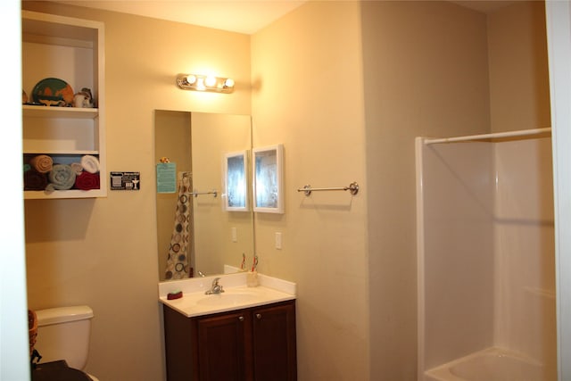 bathroom featuring vanity, toilet, and walk in shower