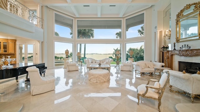 sunroom with french doors, a premium fireplace, coffered ceiling, and beamed ceiling