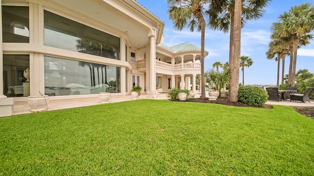 rear view of house with a patio area and a lawn