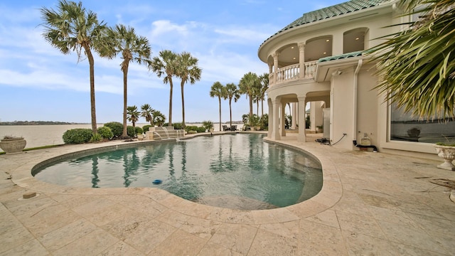 pool with a water view and a patio