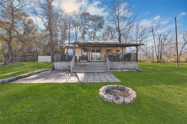 rear view of house featuring a wooden deck, a lawn, and a patio