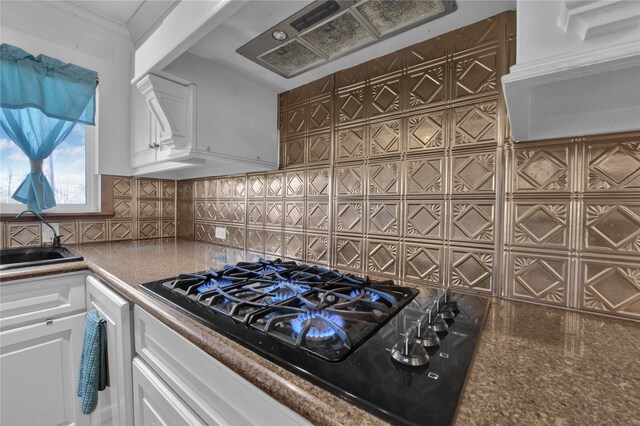 kitchen with sink, white cabinets, backsplash, and black gas stovetop