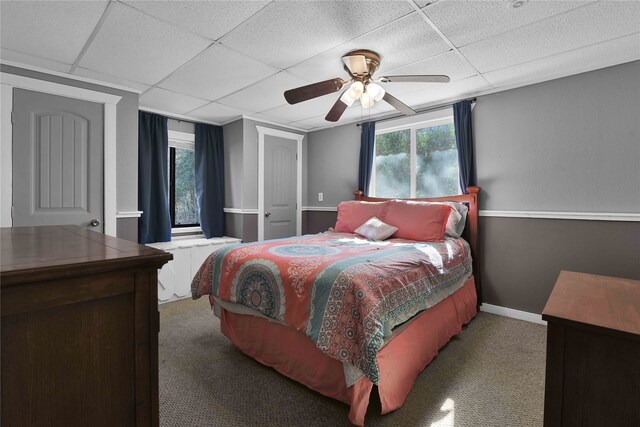 bedroom with carpet, ceiling fan, and a drop ceiling