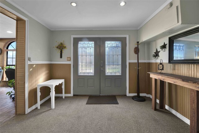 carpeted foyer featuring a wealth of natural light, french doors, and crown molding