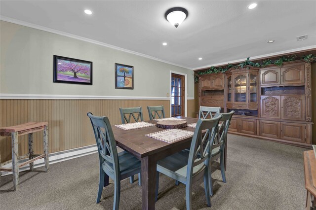 carpeted dining space with ornamental molding