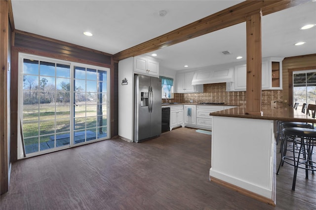 kitchen featuring white cabinets, dark hardwood / wood-style flooring, stainless steel fridge, and kitchen peninsula